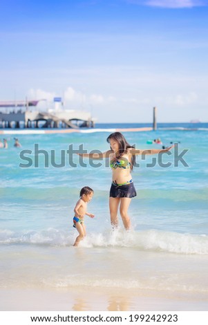 young mother and son having fun on the beach