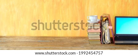 Stack of books, file folder and old laptop computer,home office, homeschooling,overwork,education, business concept. Free copy space, panoramic