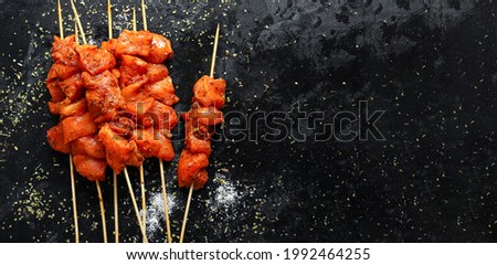 Raw chicken marinated. Top view, copy space. Raw kebab in spices. Spiced chicken thighs and wings. Royalty-Free Stock Photo #1992464255