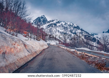 Huge snowdrifts on the sides on road to mountains. Dramatic spring scene of Theth National Park, Albania, Europe. April in Albanian highlands. Traveling concept background.