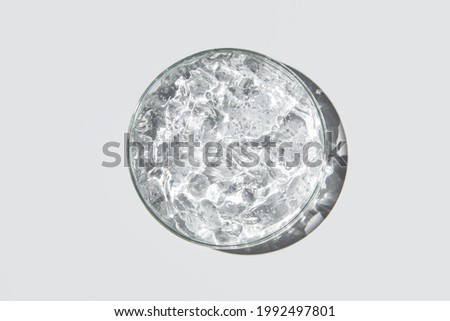 Transparent cosmetic gel in glass petri dish on white background. Concept laboratory tests and research, making cosmetic. Make-up and cosmetics texture background, skincare product. Royalty-Free Stock Photo #1992497801