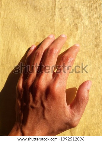 photo of hands on a yellow background