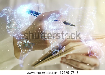 Double exposure of abstract digital world map and man hand writing in notepad on background, big data and blockchain concept