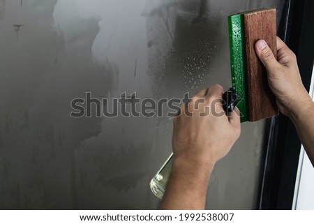 Man installing sticker film to mirror window house interior decoration