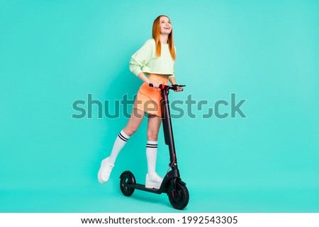 Full length photo of crazy millennial lady go scooter wear sport clothes isolated on vivid teal color background