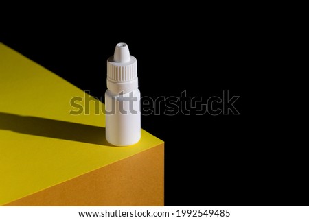 medical plastic white bottle, eye drop or ear drop bottle on a paper.