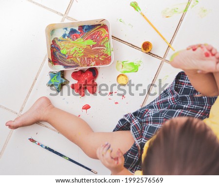 a kid playing water based paint