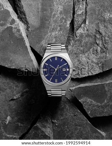 Men watch breaks rocks banner advertising product conceptual Royalty-Free Stock Photo #1992594914