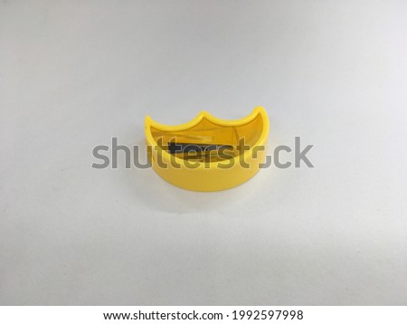 A pencil sharpener with a yellow color in the form of a crescent