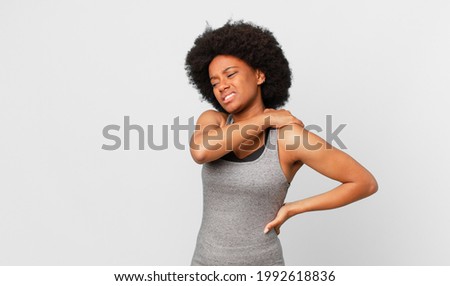 black afro woman feeling tired, stressed, anxious, frustrated and depressed, suffering with back or neck pain Royalty-Free Stock Photo #1992618836