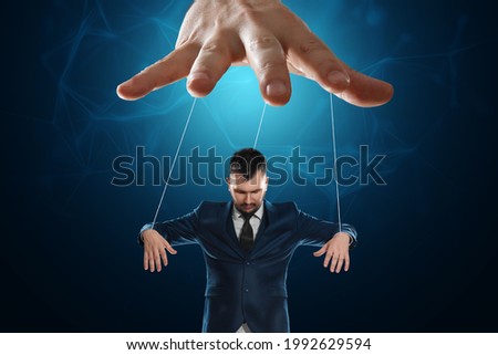 Male hand, puppeteer controls the puppet puppet with strings. A doll on her knees. The concept of world conspiracy, world government, manipulation, control Royalty-Free Stock Photo #1992629594