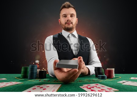 Male dealer at the casino at the table. Casino concept, gambling, poker, chips on the green casino table Royalty-Free Stock Photo #1992629612