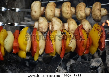 Grilled mushrooms, bell peppers and onions cooking on fire. 
