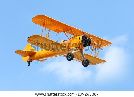 Yellow biplane on the blue sky. Royalty-Free Stock Photo #199265387