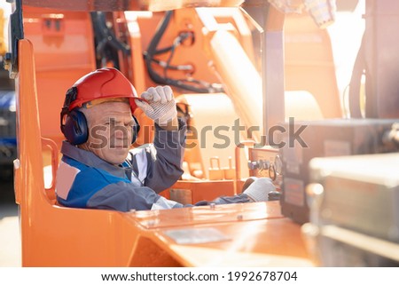 Driver yellow big truck on coal at open pit mining. Concept industry man worker. Royalty-Free Stock Photo #1992678704