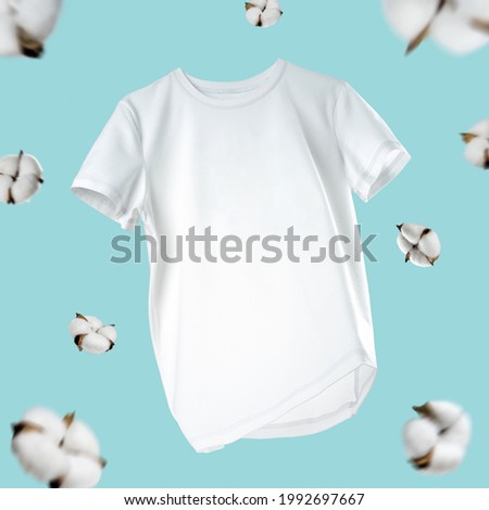 White flying cotton T-shirt isolated on turquoise background.Clean white t-shirt for women or men.   Royalty-Free Stock Photo #1992697667