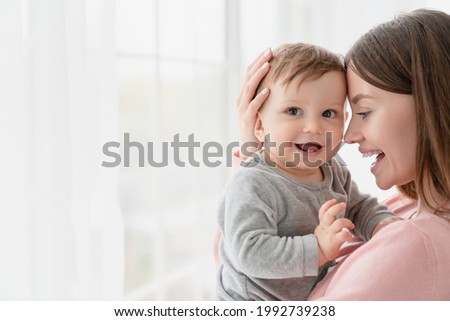 Cheerful smiling mother and little baby kid child. Family motherhood moments. Nanny childminder holding small toddler newborn baby infant with love and care. Adoption and IVF Royalty-Free Stock Photo #1992739238