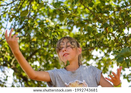 Defocused preteen blond girl on green tree summer background. Free happy childhood. Love nature. Imagination dancing ballerina. Out of focus.