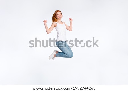 Full size profile photo of hooray red hairdo lady jump hands fists wear white top jeans isolated on bright color background