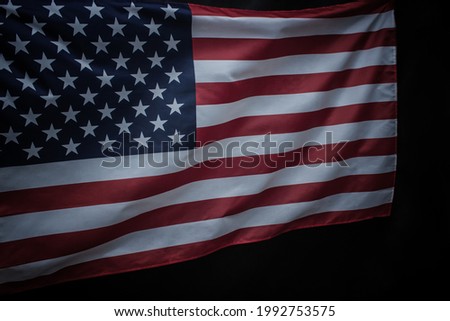 Closeup of waved USA flag over dark background