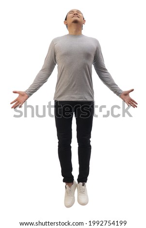 Asian man wearing grey shirt black denim and white shoes, jump flying levitation, happy expression. Full body portrait isolated cut out Royalty-Free Stock Photo #1992754199