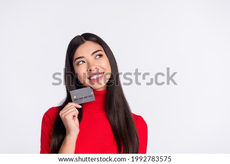 Photo of happy smiling cheerful woman look copyspace dreaming hold credit card isolated on grey color background