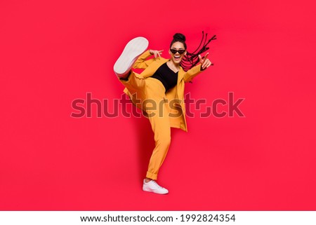 Full body photo of cool lady dance wear eyewear yellow suit isolated on vivid red color background Royalty-Free Stock Photo #1992824354