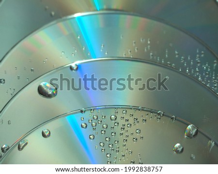 Blue reflective CD texture, small droplets of water, technology background picture.