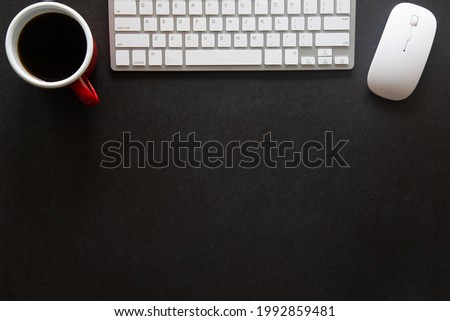 Black desk office with laptop, smartphone and other work supplies with cup of coffee. Top view with copy space for input the text. Designer workspace on desk table essential elements on flat lay.