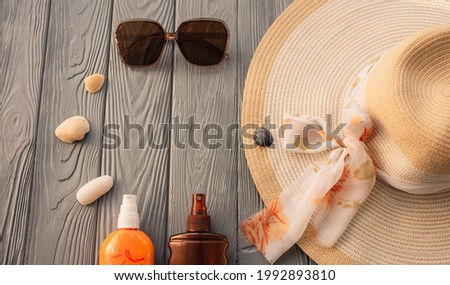 beachwear hat sun protection sunglasses sunscreen spray lotion body care tan ultra-violet rays. Summer background template mockup free space composition sample text. Top view above wooden background