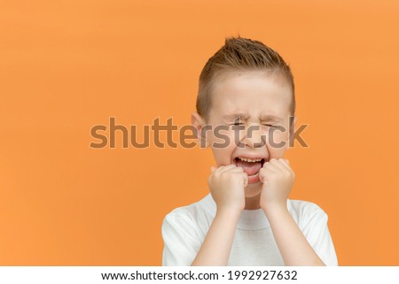 Little boy wearing t-shirt standing over isolated background angry and mad screaming with anger, frustrated and furious. Child shouting. Emotion concept. Copy space Royalty-Free Stock Photo #1992927632