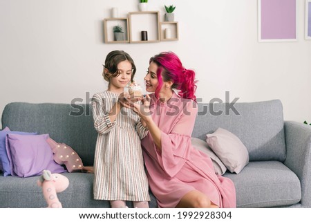 mom is happy to offer her daughter a cake for tea