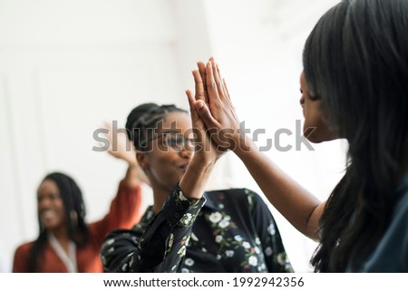 Businesswomen giving each other a high five Royalty-Free Stock Photo #1992942356