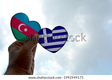 Hand holds a heart Shape Azerbaijan and Greece flag, love between two countries