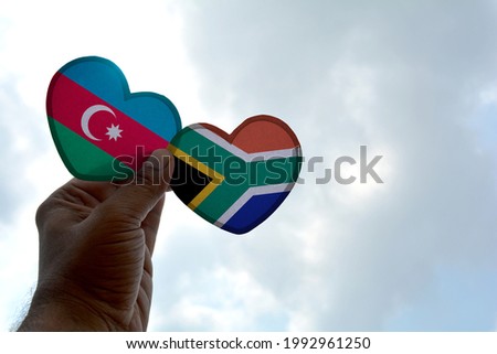 Hand holds a heart Shape Azerbaijan and South Africa flag, love between two countries