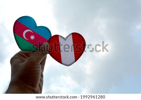 Hand holds a heart Shape Azerbaijan and Peru flag, love between two countries