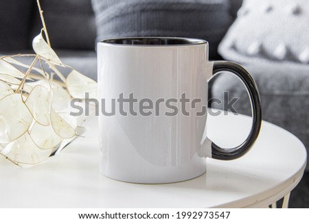 Two tone black and white mug mockup for presentation sublimation designs. Stock photos of white coffee mug ont he table with minimalist decoration for designers Royalty-Free Stock Photo #1992973547