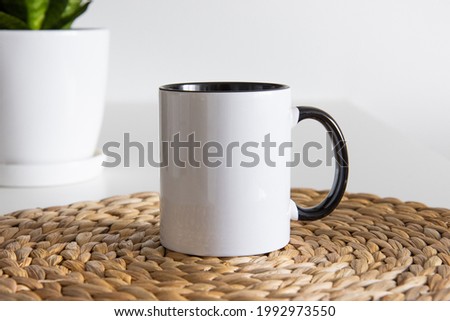 Two tone black and white mug mockup for presentation sublimation designs. Stock photos of white coffee mug ont he table with minimalist decoration for designers Royalty-Free Stock Photo #1992973550