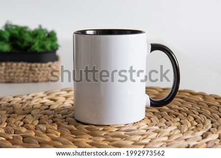 Two tone black and white mug mockup for presentation sublimation designs. Stock photos of white coffee mug ont he table with minimalist decoration for designers Royalty-Free Stock Photo #1992973562