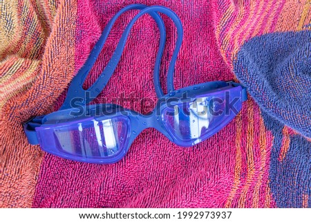 A closeup shot of blue goggles placed on top of a towel