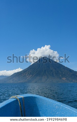 View from boat of San Pedro volcano on clear day, blue sky with few clouds, vacation day 