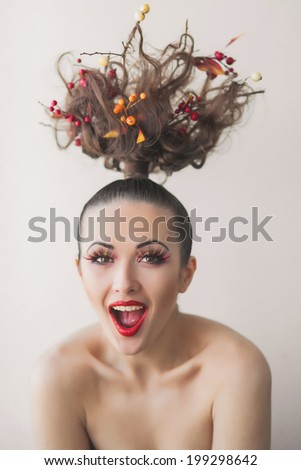 young girl posing in the room with a tree on her head