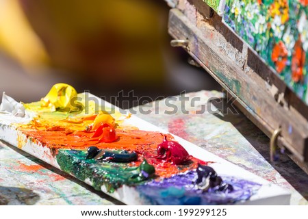 Close-up artist's pallete with oil paintings and picture