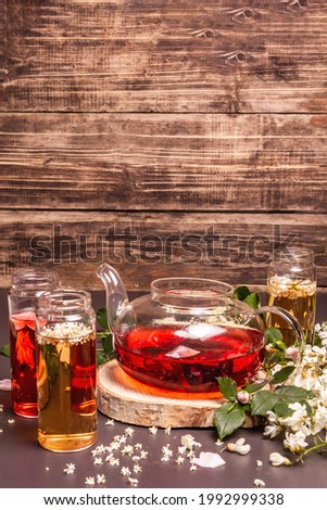 Assortment flowers tea. Fresh elderberry, rose hip, and acacia. Healthy food concept. Black stone concrete background, place for text