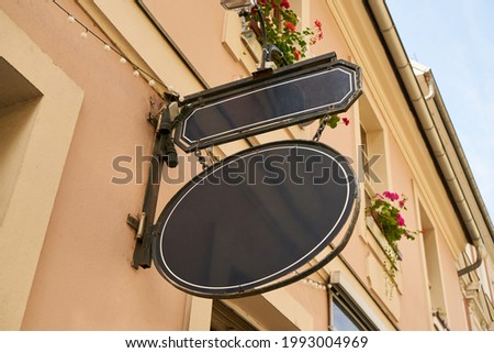 Oval vintage company sign on a building as a mock-up template for a restaurant or café