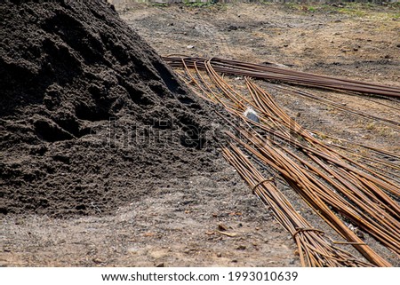 Stock photo of a large pile of black construction sand with iron or steel bar in construction site at Kolhapur Maharashtra India.