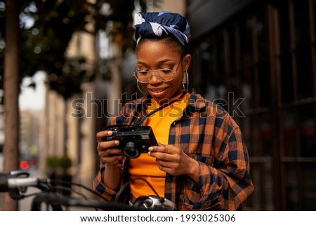 Attractive tourist with a camera. Beautiful woman with camera taking photos of beautiful location.	