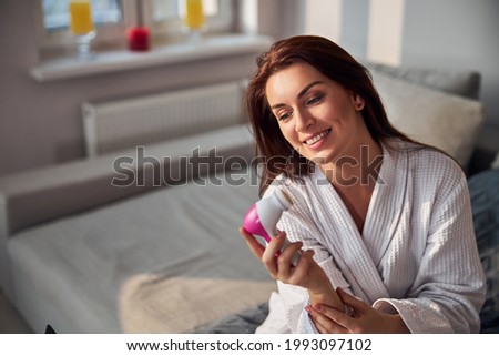 Portrait of delighted woman looking at her gadget