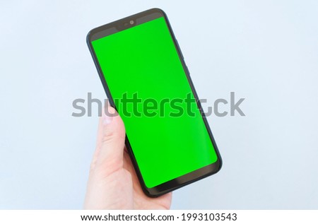 Beautiful girl holding a smartphone in the hands of a green screen green screen
