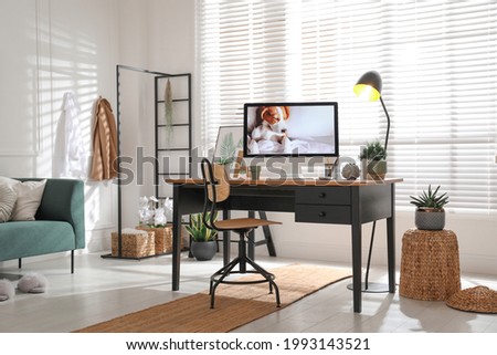 Stylish home office interior with sofa and comfortable workplace Royalty-Free Stock Photo #1993143521